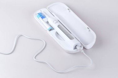 Gri yüzeyinde şarj edilebilir bataryası olan modern elektrikli ultrasonik diş fırçası. Diş bakımı.