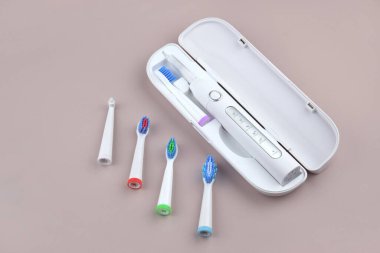 Gri yüzeyinde şarj edilebilir bataryası olan modern elektrikli ultrasonik diş fırçası. Diş bakımı.