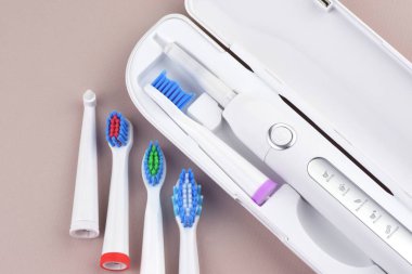 Gri yüzeyinde şarj edilebilir bataryası olan modern elektrikli ultrasonik diş fırçası. Diş bakımı.