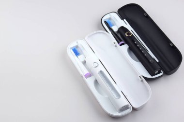 Gri yüzeyinde şarj edilebilir bataryası olan modern elektrikli ultrasonik diş fırçası. Diş bakımı.