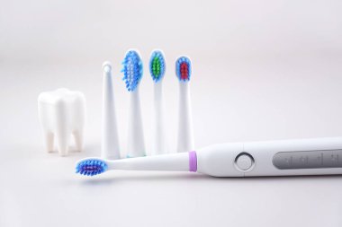Gri yüzeyinde şarj edilebilir bataryası olan modern elektrikli ultrasonik diş fırçası. Diş bakımı.