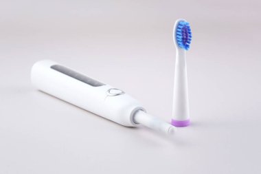 Gri yüzeyinde şarj edilebilir bataryası olan modern elektrikli ultrasonik diş fırçası. Diş bakımı.