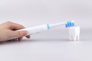 Gri yüzeyinde şarj edilebilir bataryası olan modern elektrikli ultrasonik diş fırçası. Diş bakımı.
