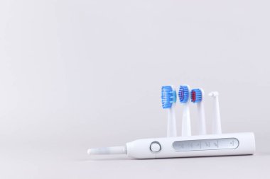 Gri yüzeyinde şarj edilebilir bataryası olan modern elektrikli ultrasonik diş fırçası. Diş bakımı.