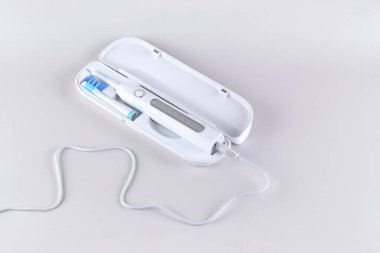 Gri yüzeyinde şarj edilebilir bataryası olan modern elektrikli ultrasonik diş fırçası. Diş bakımı.