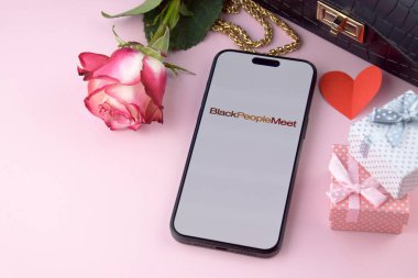 KHARKIV, UKRAINE - 12 Haziran 2024: Siyahiler akıllı telefon ekranında flört uygulaması ile buluştu. Randevu ve aile kavramı.