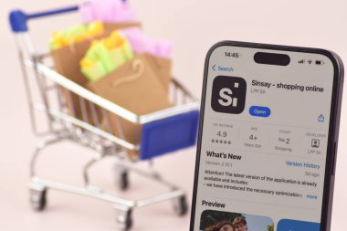 KHARKOV, UKRAINE - 18 Ağustos 2024: Akıllı telefonlu alışveriş arabası ekranda Sinsay uygulaması açık.