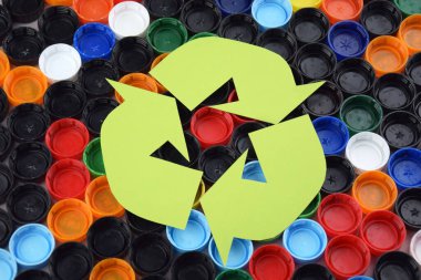 Kharkiv, Ukrayna - 25 Ocak 2025: Geri dönüşüm işaretli plastik şişe kapakları. Geri dönüşüm kavramı.