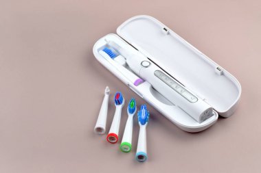 Gri yüzeyinde şarj edilebilir bataryası olan modern elektrikli ultrasonik diş fırçası. Diş bakımı.