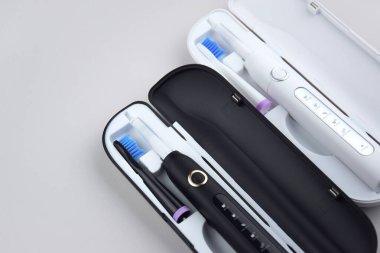 Gri yüzeyinde şarj edilebilir bataryası olan modern elektrikli ultrasonik diş fırçası. Diş bakımı.