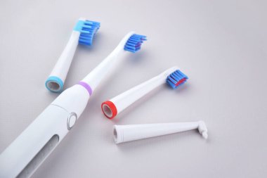 Gri yüzeyinde şarj edilebilir bataryası olan modern elektrikli ultrasonik diş fırçası. Diş bakımı.
