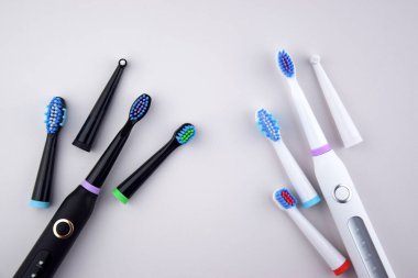 Gri yüzeyinde şarj edilebilir bataryası olan modern elektrikli ultrasonik diş fırçası. Diş bakımı.