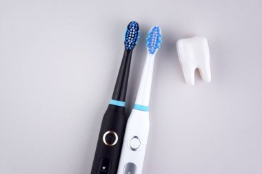 Gri yüzeyinde şarj edilebilir bataryası olan modern elektrikli ultrasonik diş fırçası. Diş bakımı.