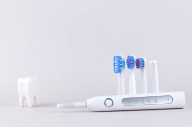 Gri yüzeyinde şarj edilebilir bataryası olan modern elektrikli ultrasonik diş fırçası. Diş bakımı.