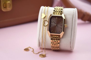 Pembe arka plandaki kadınlar için en az moda kol saati. Moda ve tarz.