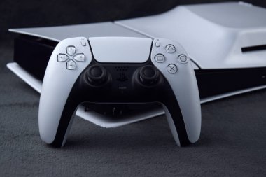 Kharkiv, Ukrayna - 10 Temmuz 2025: Beyaz Sony PlayStation 5 ve karanlık masa üzerindeki denetleyici.