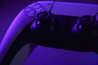 Kharkiv, Ukrayna - 10 Temmuz 2025: Beyaz Sony PlayStation 5 ve karanlık masa üzerindeki denetleyici.