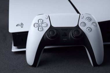 Kharkiv, Ukrayna - 10 Temmuz 2025: Beyaz Sony PlayStation 5 ve karanlık masa üzerindeki denetleyici.