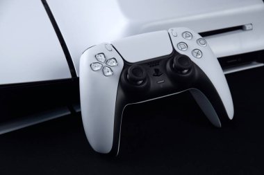 Kharkiv, Ukrayna - 10 Temmuz 2025: Beyaz Sony PlayStation 5 ve karanlık masa üzerindeki denetleyici.