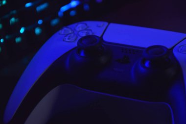 Kharkiv, Ukrayna - 10 Temmuz 2025: Beyaz Sony PlayStation 5 ve karanlık masa üzerindeki denetleyici.