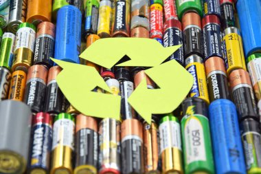 Kharkiv, Ukrayna - 20 Temmuz 2025: Kullanılmış AA bataryalar ve çevresel ve toprak toksik bataryaların yeşil arka planda düzgün bir şekilde imha edilmesi.