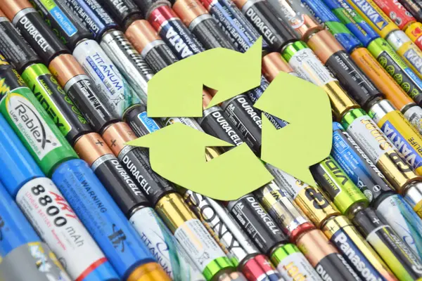 Kharkiv, Ukrayna - 20 Temmuz 2025: Kullanılmış AA bataryalar ve çevresel ve toprak toksik bataryaların yeşil arka planda düzgün bir şekilde imha edilmesi.