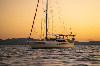 Avustralya 'da dalgalar ve yatlarla altın ışık altında gün batımı