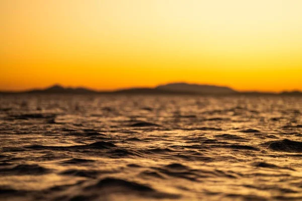 オーストラリアの波とヨットで黄金の光の海に沈む夕日 — ストック写真