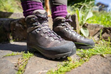 İlkbaharda yürüyüş yapan bir kız tarafından yürüyüş botlarına ayakkabı bağcıkları bağlanmış.