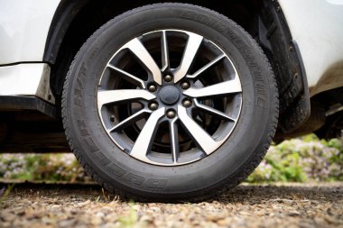 Kırsalda lastik değiştiren bir kadın. Kız tamirci çalılıklarda lastik değiştiriyor.