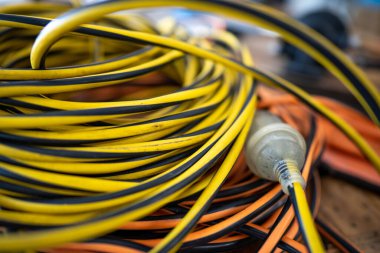 Bir inşaat sahasında elektrik kablosu, dışarıda da elektrikçi.