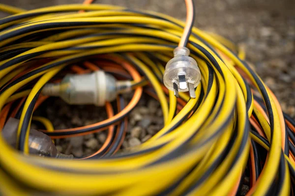 extension cord wrapped up on the ground. extension lead, power lead on a construction site