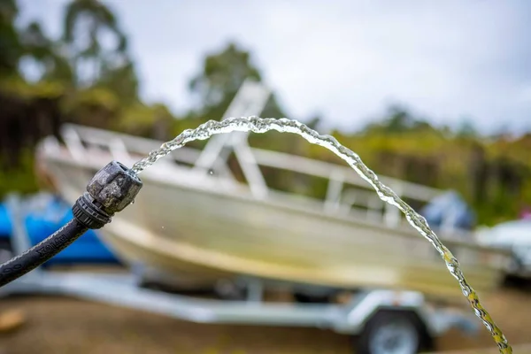 filling up water tank of caravan while camping. washing car and boat in summer