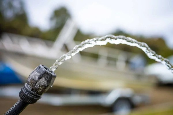 filling up water tank of caravan while camping. washing car and boat in summer