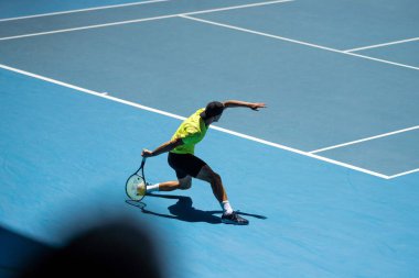 tennis fan watching a tennis match at the australian open eating food and drinking