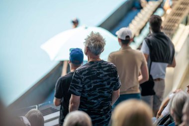 tennis fan watching a tennis match at the australian open eating food and drinking in australia