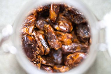 dried fruit, dates, prunes, grains, wheat, lentils, rice stored in glass jars in a kitchen in australia