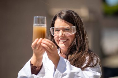 Kadın toprak bilimci pipette toprak çözeltisi bir laboratuarda. Avusturalya tarımında çalışan bilim adamı
