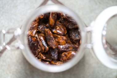 dried fruit, dates, prunes, grains, wheat, lentils, rice stored in glass jars in a kitchen in australia