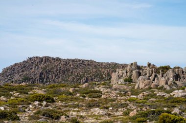 peak of a rocky mountain in a national park looking over a city below, mt wellington hobart tasmania australia in summer