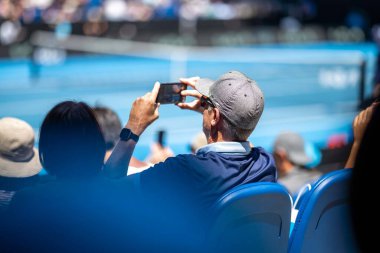 Amateur playing tennis at a tournament and match on grass in Melbourne, Australia in summer