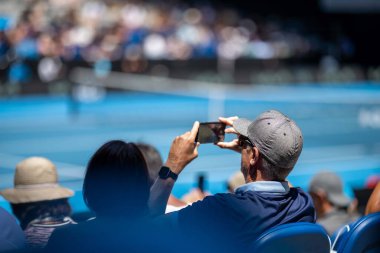 tennis fan watching a tennis match at the australian open eating food and drinking in australia
