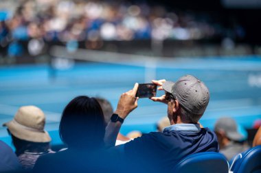 tennis fan watching a tennis match at the australian open eating food and drinking in australia