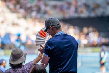 Amatör bir turnuvada tenis oynuyor ve yazın Avustralya 'nın Melbourne şehrinde çimlerin üzerinde maç yapıyor.