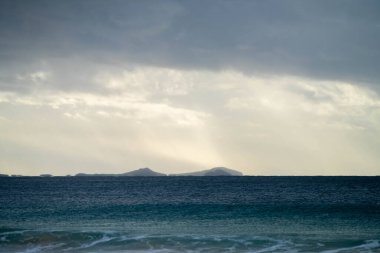 Alacakaranlıkta dalgaları ve adası olan güzel Avustralya plajı