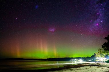 Aurora Australis kışın Tazmanya Avustralya 'da bir sahil kasabasında kumlu bir plaja çıkıyor.