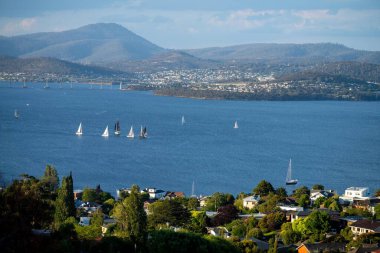 Hobart 'ta nehir kenarındaki yat yarışı bitti. Okyanusta yarışan yatlar. Avustralya 'da tekne yarışı