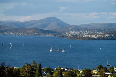 Hobart 'ta nehir kenarındaki yat yarışı bitti. Okyanusta yarışan yatlar. Avustralya 'da tekne yarışı