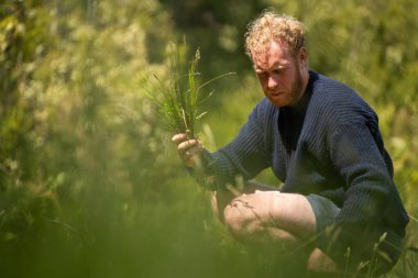 Yenileyici organik çiftçi, toprak örnekleri alıyor ve bir çiftlikteki bitkilere bakıyor. bir alanda sürdürülebilir tarım uygulaması