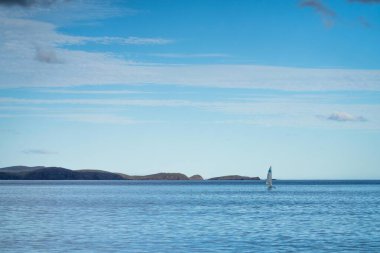 Pembe bulutlar ve okyanusla şafak vakti güzel, kumral bir ada.